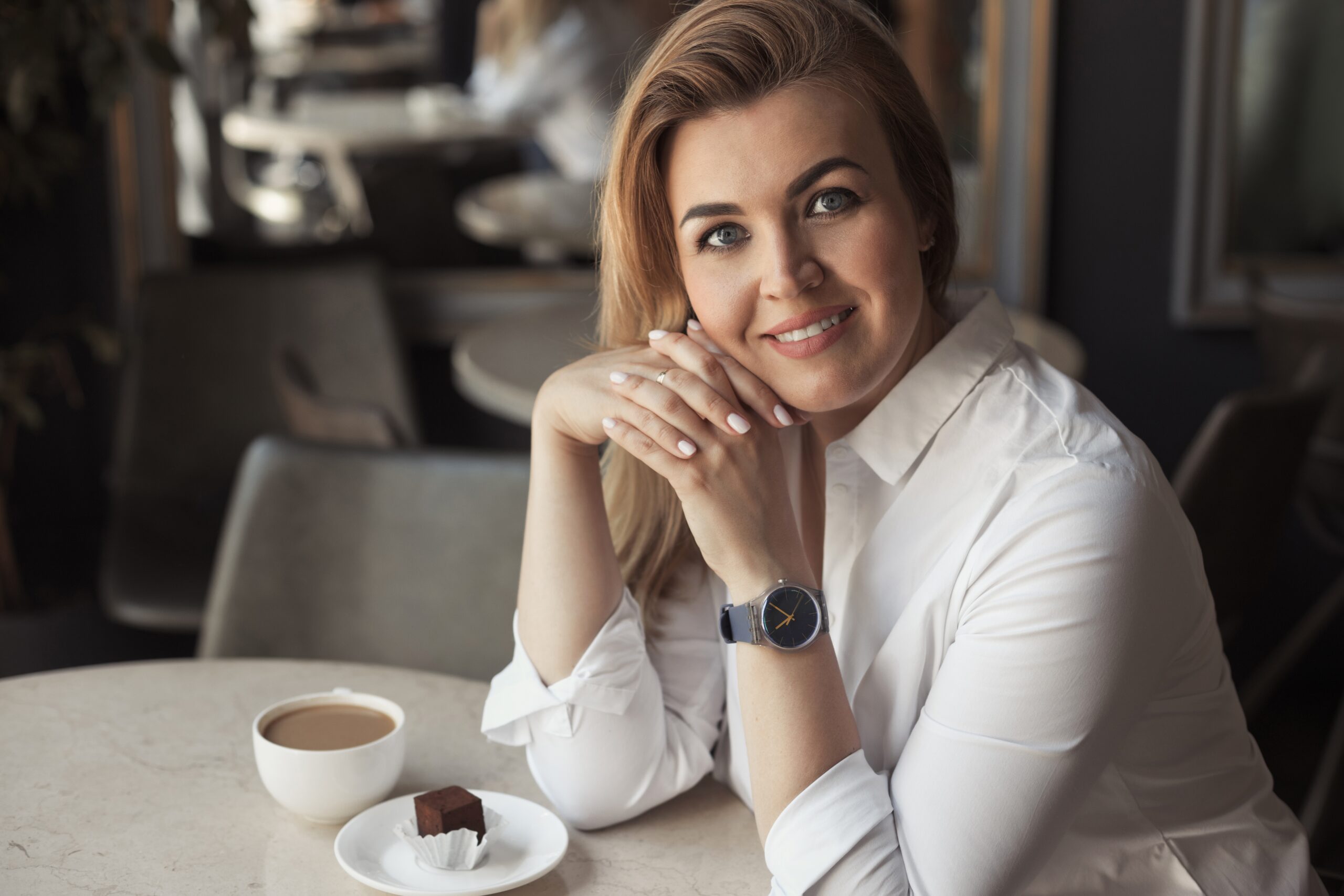 Mulher de 40 anos sorrindo em uma mesa