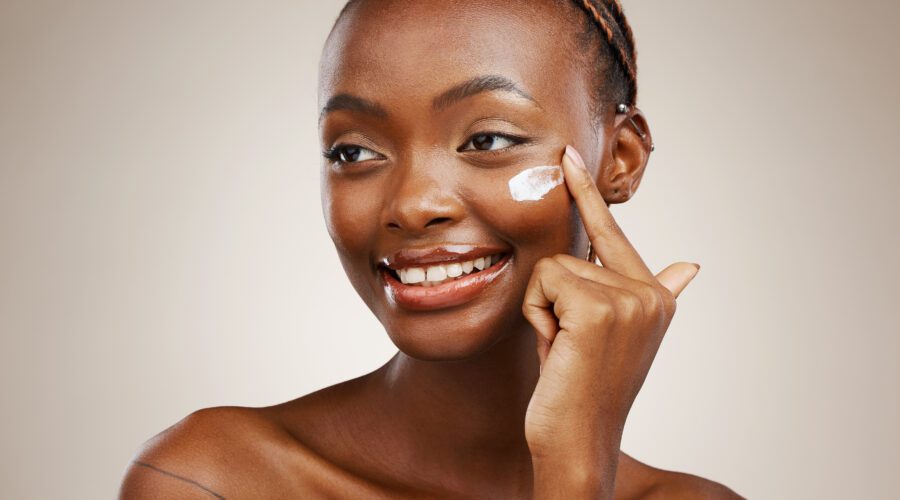 Mulher passando creme no rosto, fazendo Skin Cycling: