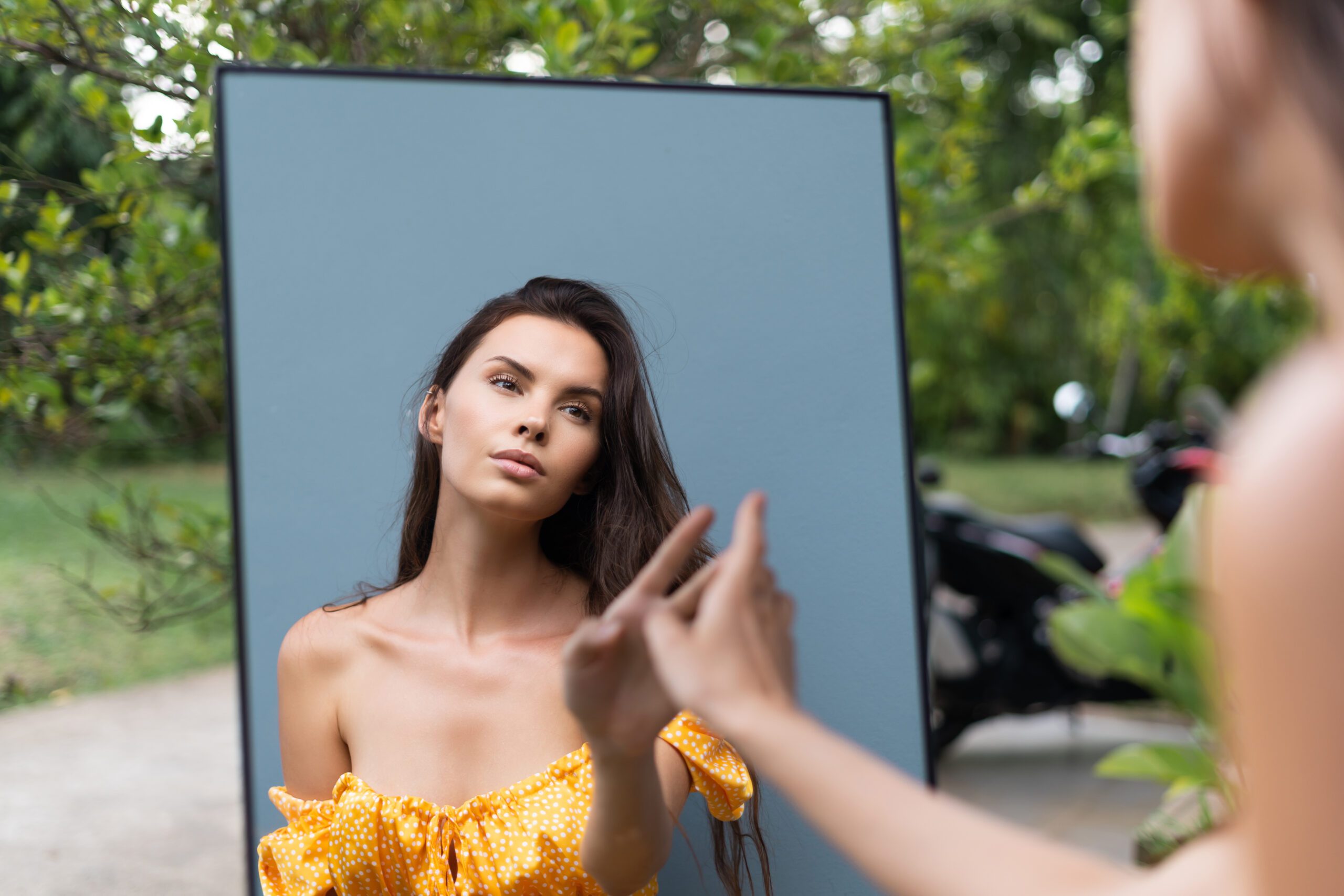 Mulher com vestido amarelo, em frente ao espelho