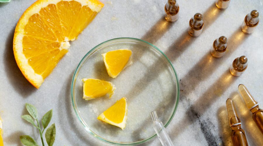 Laranja e uma seringa em cima de uma mesa.