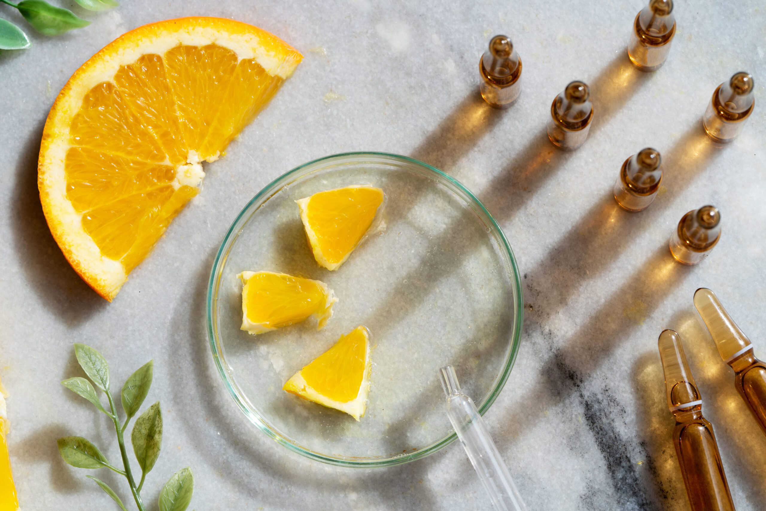 Laranja e uma seringa em cima de uma mesa.