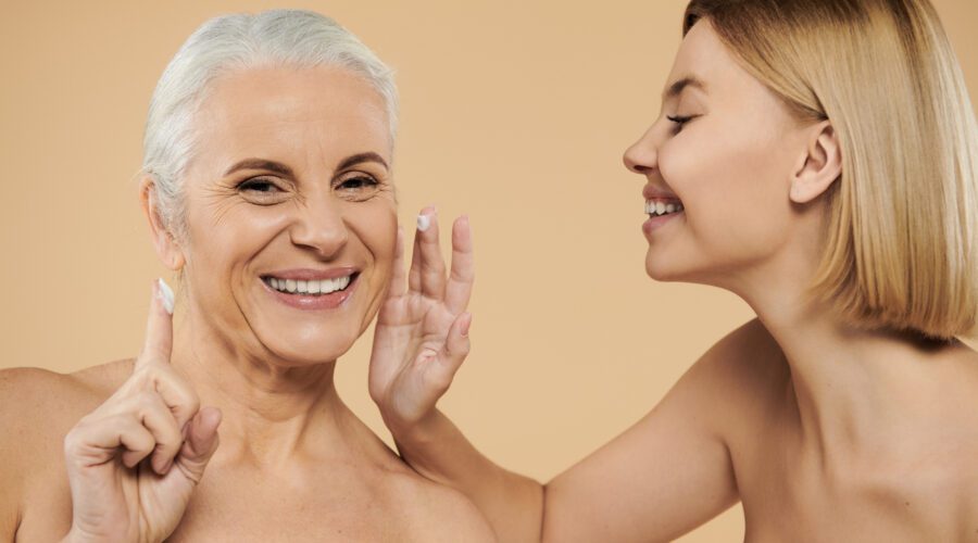 Duas mulheres de idades diferentes passando creme no rosto.