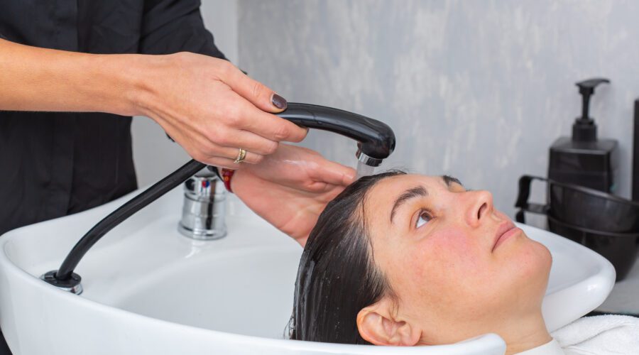 Cabeleireiro lavando o cabelo para uma jovem cliente