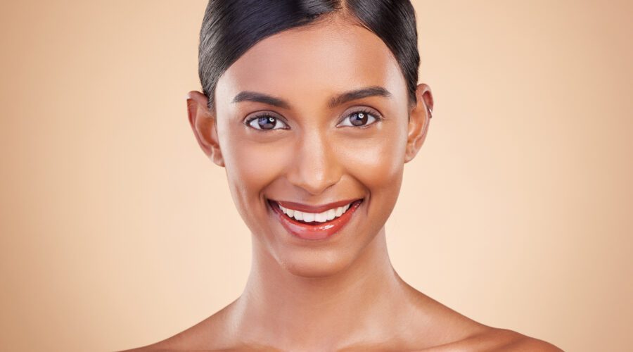 Retrato, beleza e sorriso com uma mulher modelo em estúdio em um fundo bege para cuidados naturais
